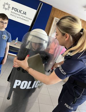 policjantka z chłopcem trzymającym policyjną tarczę