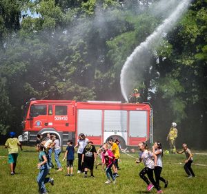 wóz strażacki polewający wodą dzieci