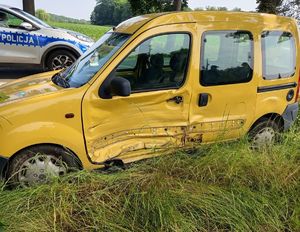 żółte renault z rozbitym bokiem w tle radiowóz policyjny