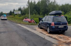 granatowy rozbity opel przed nim rowie czerwone terenowe volvo z kołami do góry na ulicy stoi radiowóz