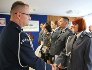 komendant gratulujący policjantce stojącej w szeregu