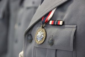 Brązowa odznaka zasłużony policjant na mundurze