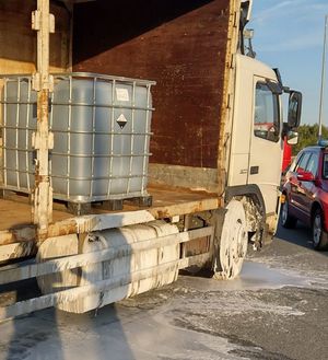 białe ciężarowe volvo z odsłoniętą naczepą na niej plastikowy zbiornik