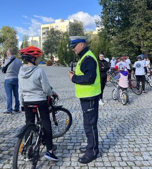 policjant z odblaskami rozmawia z nastolatkiem na rowerze