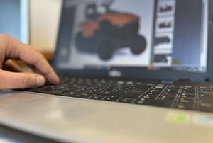 dłoń nad klawiaturą komputera na ekranie traktorek ogrodowy