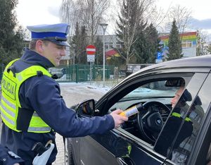 policjant badający na trzeźwość kierowcę