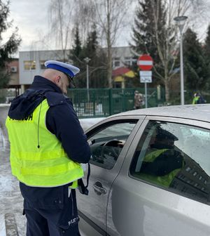 policjant stojący obok samochodu