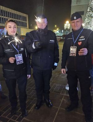 troje policjantów trzymających zimne ognie