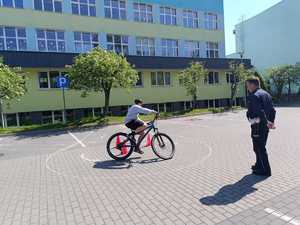 chłopiec na rowerze obok policjant