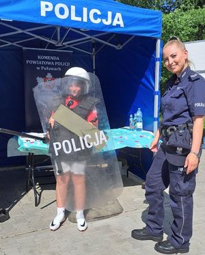 policjantka z dzieckiem z tarczą i w hełmie