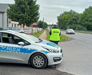 policjant obok radiowozu na ulicy