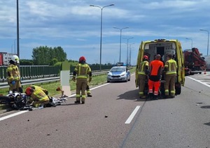 przewrócony motocykl na drodze obok strażacy