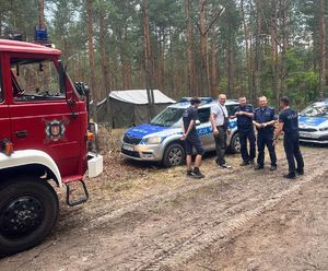 wóz straży pożarnej obok radiowozy i policjanci