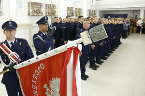 policjant ze sztandarem KWP w Lublinie w tle pododdział nowo przyjętych policjantów