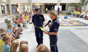 policjantka czytająca dziecku pytanie obok niej policjant