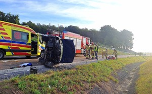 rozbity samochód obok karetka w tle policjantka i strażacy