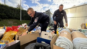 dwóch policjantów wśród pudeł z darami