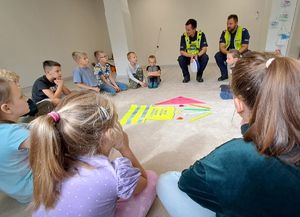 policjanci siedzący w kręgu z dziećmi