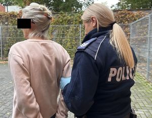 policjantka prowadząca zatrzymaną kobietę