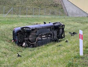 samochód osobowy leżący na boku na trawie