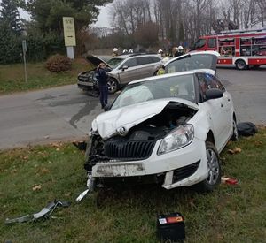 rozbita biała skoda i beżowe subaru w tle wóz strażacki strażacy i policjanci