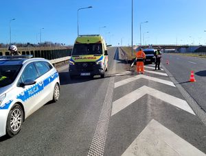 rozbita biała dacia na drodze s17 obok karetka i radiowóz