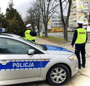 policjanci ruchu drogowego obok radiowozu niedaleko przejścia dla pieszych na ulicy Centralnej w Puławach