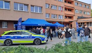 stoiska policyjne i radiowóz przy nich uczniowie