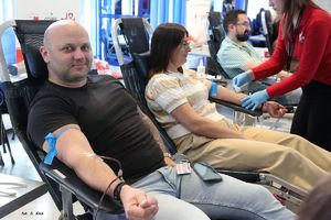 policjant oddający krew obok niego inne osoby oddające krew