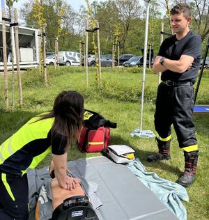 strażak instruujący kobietę podczas nauki resuscytacji na manekinie