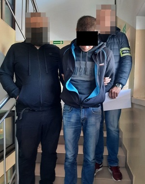 policjanci prowadzący zatrzymanego