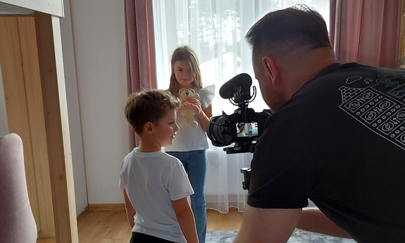mężczyzna z kamerą nagrywający dzieci