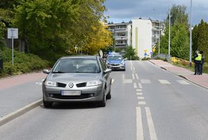 szare Renault za nim radiowóz pośrodku przejście dla pieszych