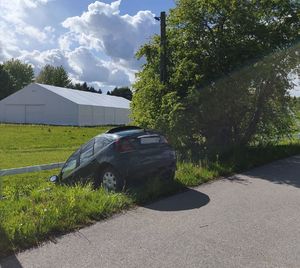 zielony Rover stojący przodem w rowie oparty o ogrodzenie