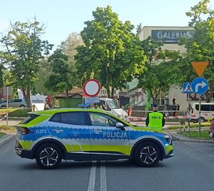 radiowóz na ulicy obok policjant