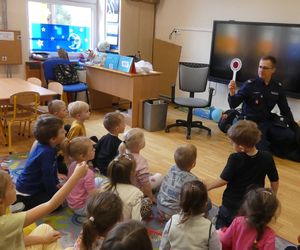 policjant pokazujący dzieciom tarczę do zatrzymywania pojazdów