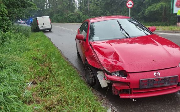 czerwona rozbita mazda w tle biały bus