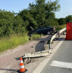 miejsce wypadku drogowego czarny opel za barierą fragment czerwonego parawanu