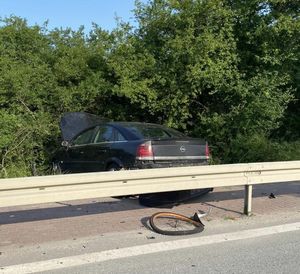 czarny opel za barierą przed barierą koło od roweru