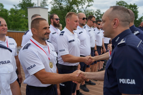 Jacek Bigos wśród innych policjantów odbierający gratulacje