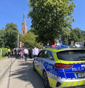 radiowóz jadący za pielgrzymami zbliżającymi się do sanktuarium