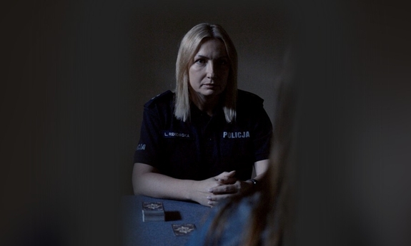 Policjantka przy stole w ciemności