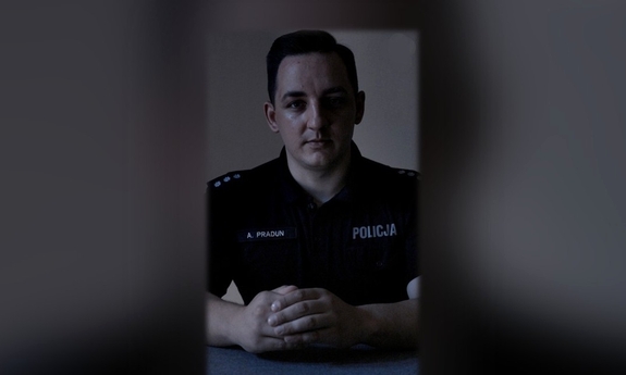 policjant w zacienionym pomieszczeniu