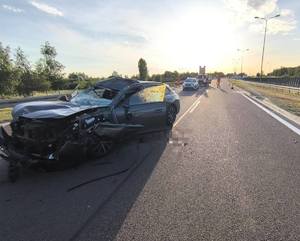 rozbity Peugeot na drodze w tle radiowóz i inne pojazdy