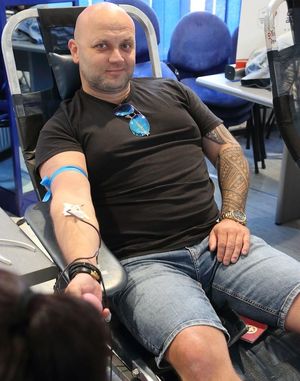 policjant po cywilnemu na fotelu w trakcie oddawania krwi