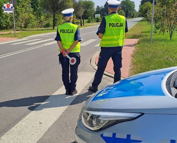 dwoje policjantów ruchu drogowego patrzących na drogę