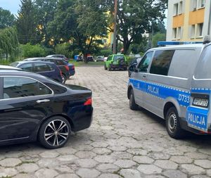 policyjny bus na parkingu między samochodami