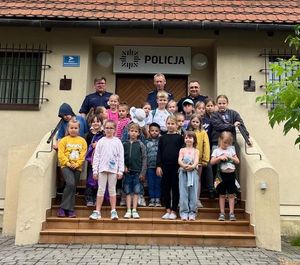 trzech policjantów z grupą dzieci przed Komisariatem Policji w Kazimierzu Dolnym