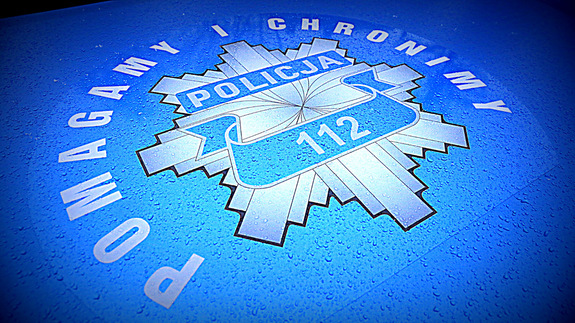 policyjna odznaka i napis pomagamy i chronimy