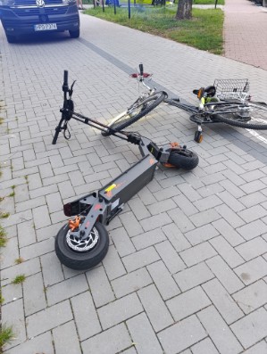 rower i hulajnoga leżą na drodze rowerowej
